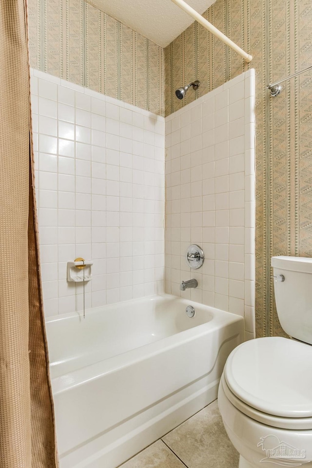 bathroom featuring tile patterned floors, tiled shower / bath combo, and toilet