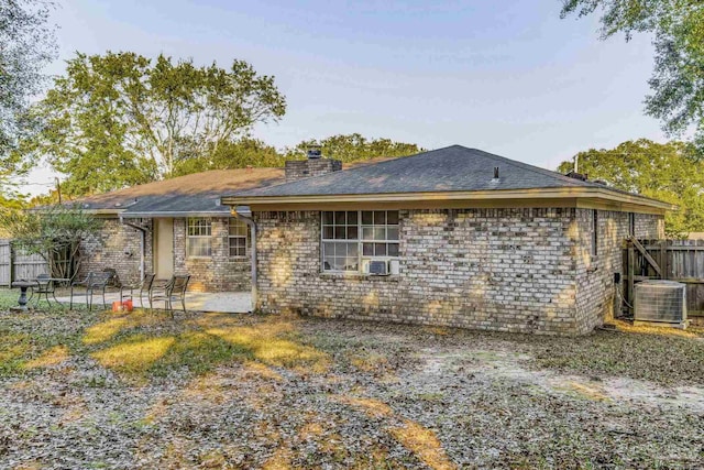 rear view of property featuring central air condition unit, cooling unit, and a patio