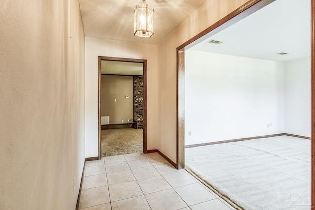 hall featuring a chandelier and light colored carpet