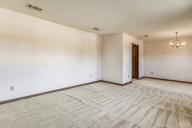 unfurnished room featuring light colored carpet and an inviting chandelier