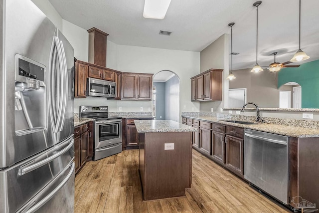 kitchen featuring a kitchen island, pendant lighting, sink, dark brown cabinetry, and stainless steel appliances