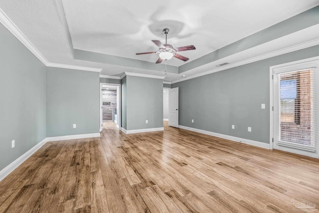 interior space with a raised ceiling, ceiling fan, ornamental molding, and light wood-type flooring