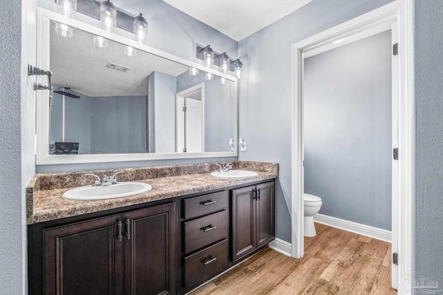 bathroom with vanity, toilet, and hardwood / wood-style floors