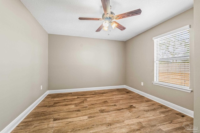 unfurnished room with ceiling fan, wood-type flooring, and a textured ceiling