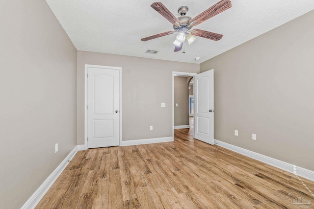 unfurnished bedroom featuring a textured ceiling, light hardwood / wood-style floors, and ceiling fan