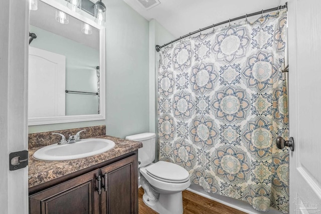 bathroom featuring vanity, wood-type flooring, and toilet