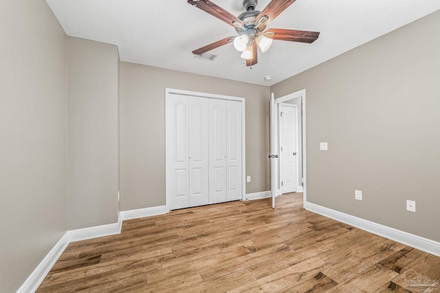 unfurnished bedroom featuring wood-type flooring, a closet, and ceiling fan