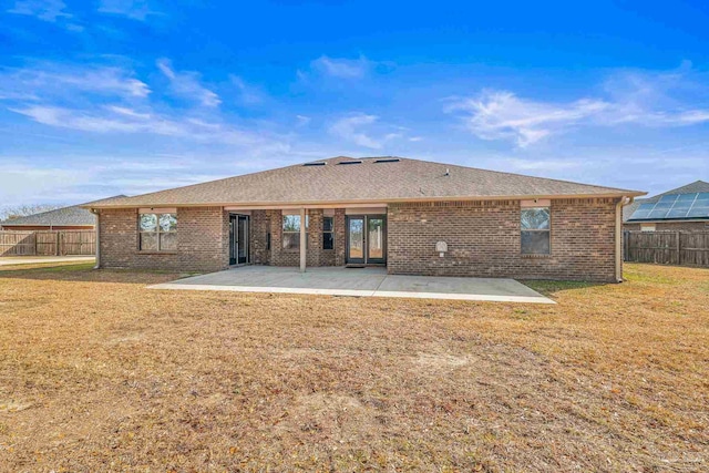 rear view of house with a patio and a yard