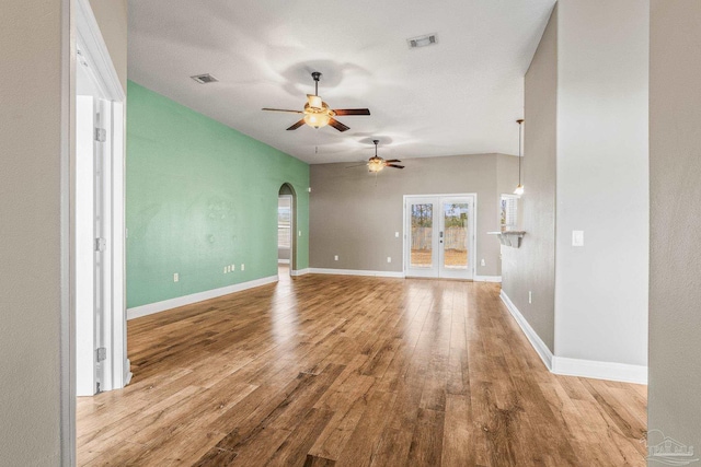 unfurnished living room with ceiling fan, light hardwood / wood-style floors, and french doors