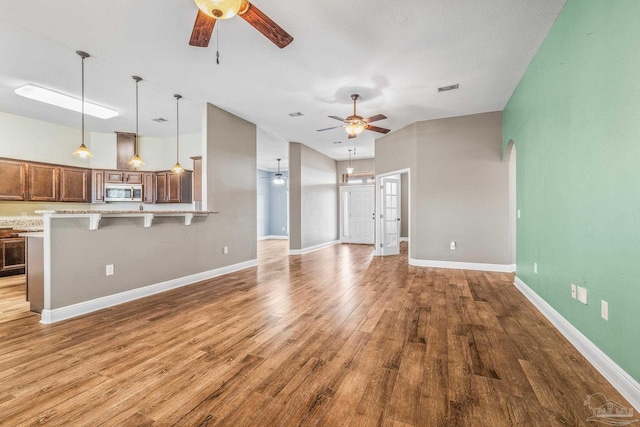 unfurnished living room with hardwood / wood-style flooring and ceiling fan