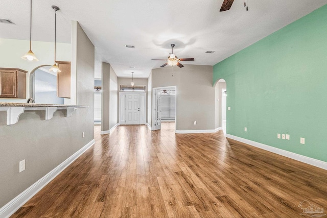 unfurnished living room with hardwood / wood-style floors and ceiling fan