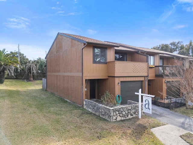 exterior space with a balcony, a front yard, and a garage