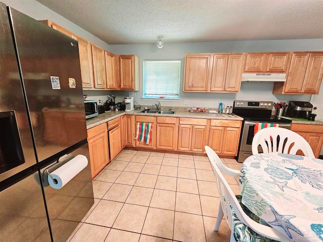 kitchen featuring sink, stainless steel appliances, a textured ceiling, and light tile patterned floors