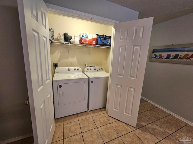 laundry area featuring washer and dryer, a textured ceiling, and light tile patterned floors