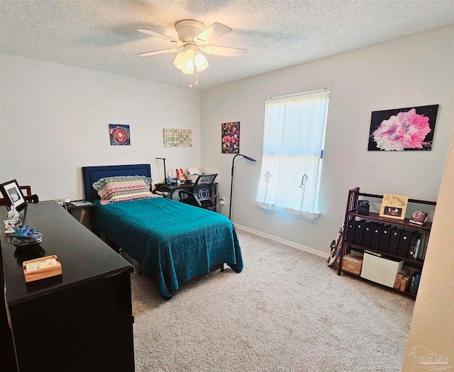 carpeted bedroom featuring ceiling fan and a textured ceiling