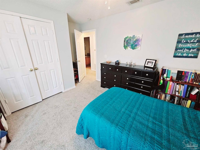 carpeted bedroom with a closet and a textured ceiling