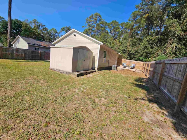 back of house featuring a storage unit and a lawn