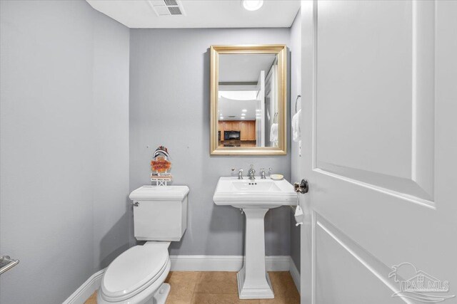 3 Portofino Dr Unit 1705, Pensacola Beach, FL 32561 - half bath featuring toilet, baseboards, tile patterned flooring, and a sink