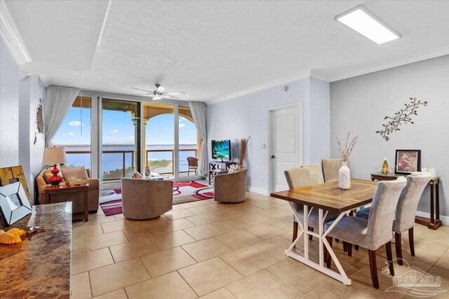 3 Portofino Dr Unit 1705, Pensacola Beach, FL 32561 - dining space with ornamental molding, a ceiling fan, light tile patterned floors, baseboards, and a textured ceiling