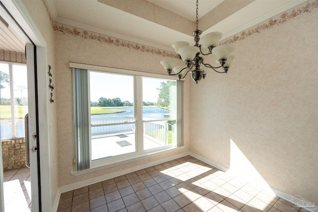 empty room featuring ornamental molding, a notable chandelier, a water view, and light tile patterned floors