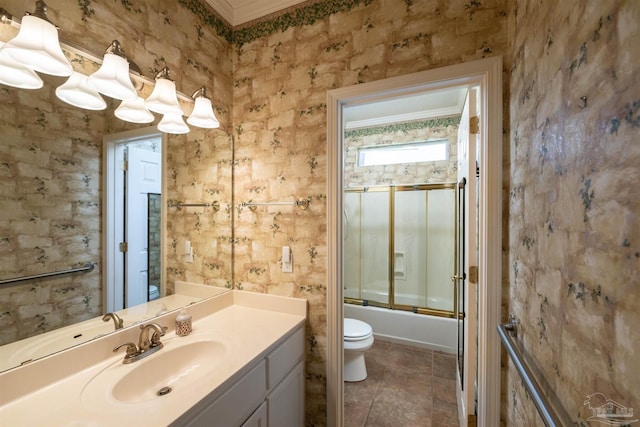 full bathroom with tile patterned floors, toilet, crown molding, bath / shower combo with glass door, and vanity