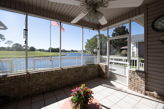 unfurnished sunroom featuring a water view and ceiling fan