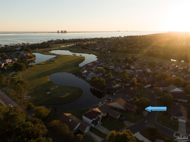 aerial view at dusk featuring a water view