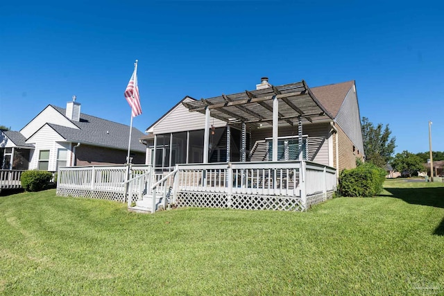 back of property with a wooden deck, a sunroom, a lawn, and a pergola