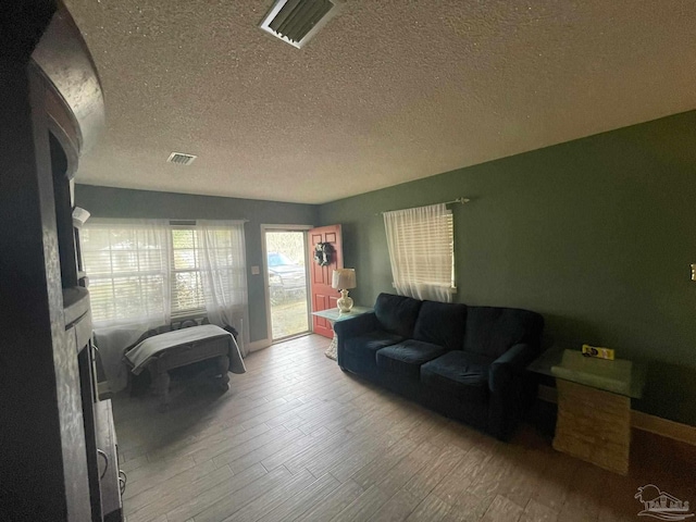 living room with hardwood / wood-style floors and a textured ceiling