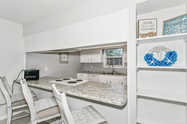3382 Green Briar Cir, Gulf Breeze, FL 32563 - kitchen with a peninsula, a breakfast bar area, white appliances, white cabinets, and built in desk