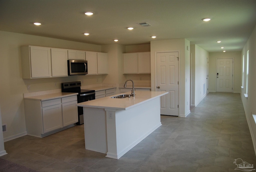 4746 Majestic Palm St, Pace, FL 32571 - kitchen with stainless steel appliances, white cabinetry, a kitchen island with sink, recessed lighting, and light countertops