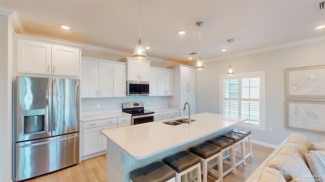14379 Cordgrass Ln, Pensacola, FL 32507 - kitchen featuring ornamental molding, appliances with stainless steel finishes, an island with sink, a sink, and light wood-style floors
