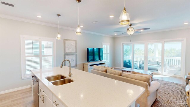 kitchen with hanging light fixtures, plenty of natural light, sink, and white cabinetry