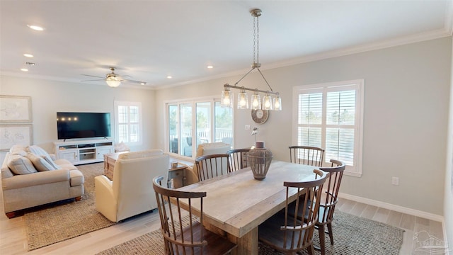 dining room featuring ceiling fan with notable chandelier, crown molding, and light hardwood / wood-style floors