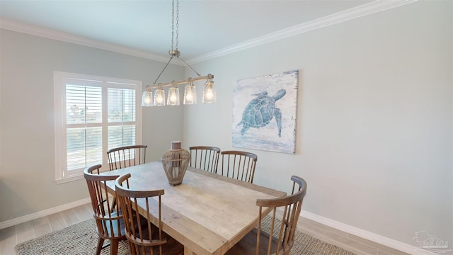 dining space with hardwood / wood-style flooring and ornamental molding