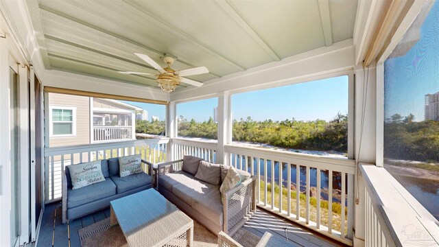 sunroom with ceiling fan and beam ceiling