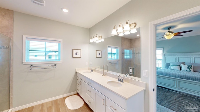 bathroom with walk in shower, vanity, hardwood / wood-style floors, and ceiling fan