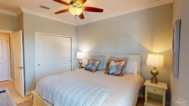 bedroom featuring ceiling fan, light colored carpet, a closet, and crown molding