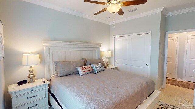 carpeted bedroom featuring crown molding, ceiling fan, and a closet