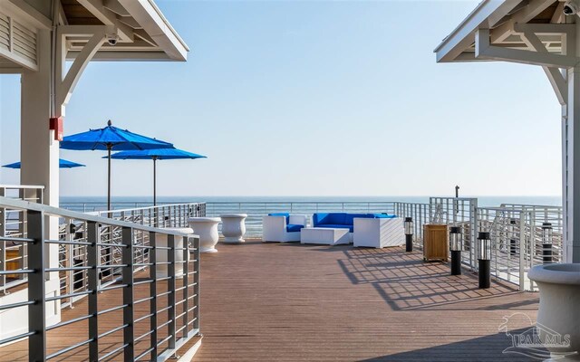 wooden terrace featuring a water view and an outdoor hangout area