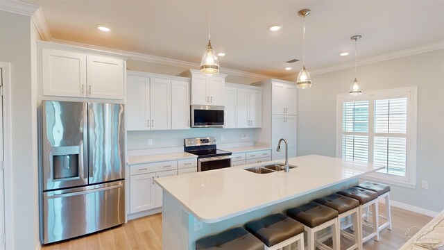 kitchen featuring decorative light fixtures, stainless steel appliances, sink, and white cabinetry