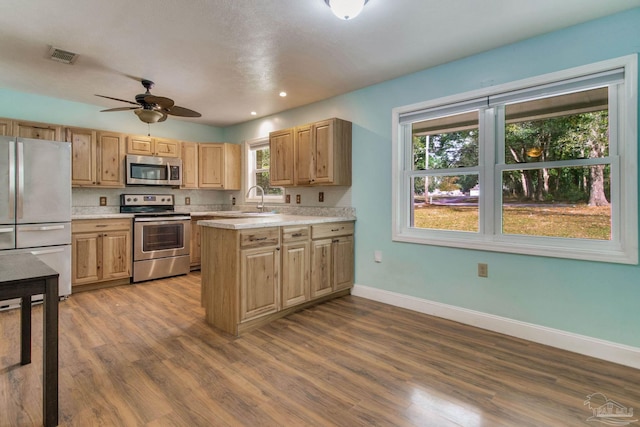 kitchen featuring dark wood-style flooring, stainless steel appliances, light countertops, visible vents, and baseboards