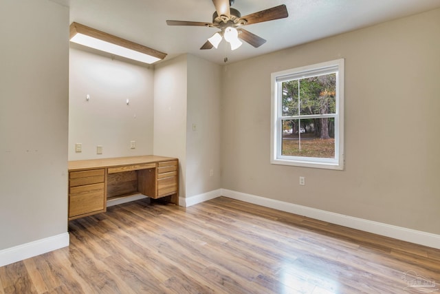 unfurnished office featuring a ceiling fan, light wood-style flooring, and baseboards