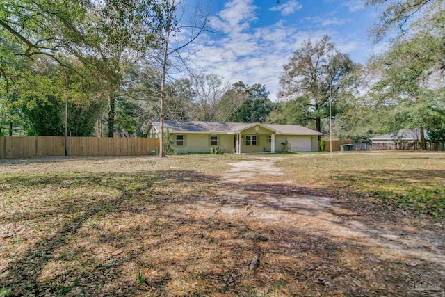 view of front of house featuring an attached garage and fence