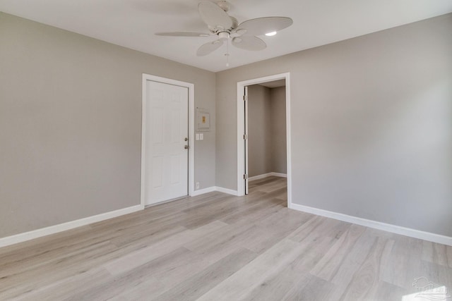 unfurnished room featuring light wood-style floors, baseboards, and a ceiling fan