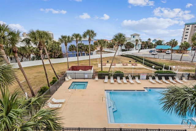 view of swimming pool with a hot tub and a patio area