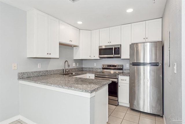 kitchen with sink, light tile patterned floors, stainless steel appliances, white cabinets, and kitchen peninsula