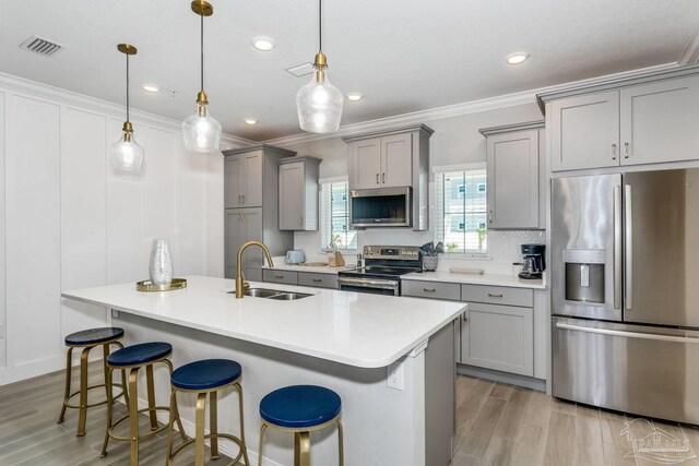 kitchen with pendant lighting, sink, a breakfast bar, and appliances with stainless steel finishes