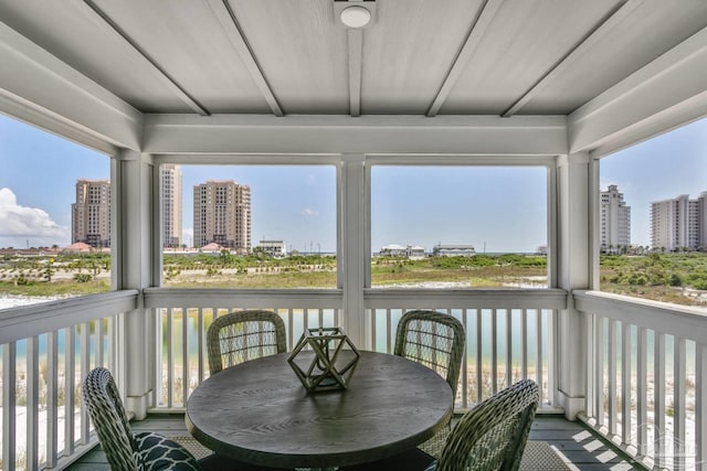 sunroom / solarium featuring beamed ceiling