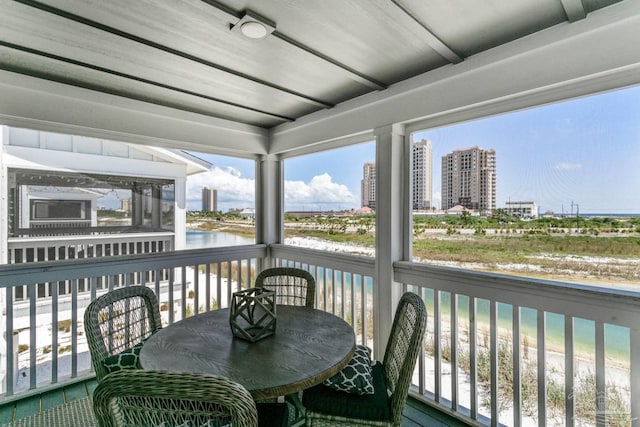 sunroom / solarium with a water view and a healthy amount of sunlight